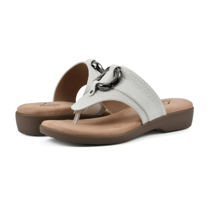 Angle view of a pair of white thong sandals with a centered metal ring ornament and tan sole
