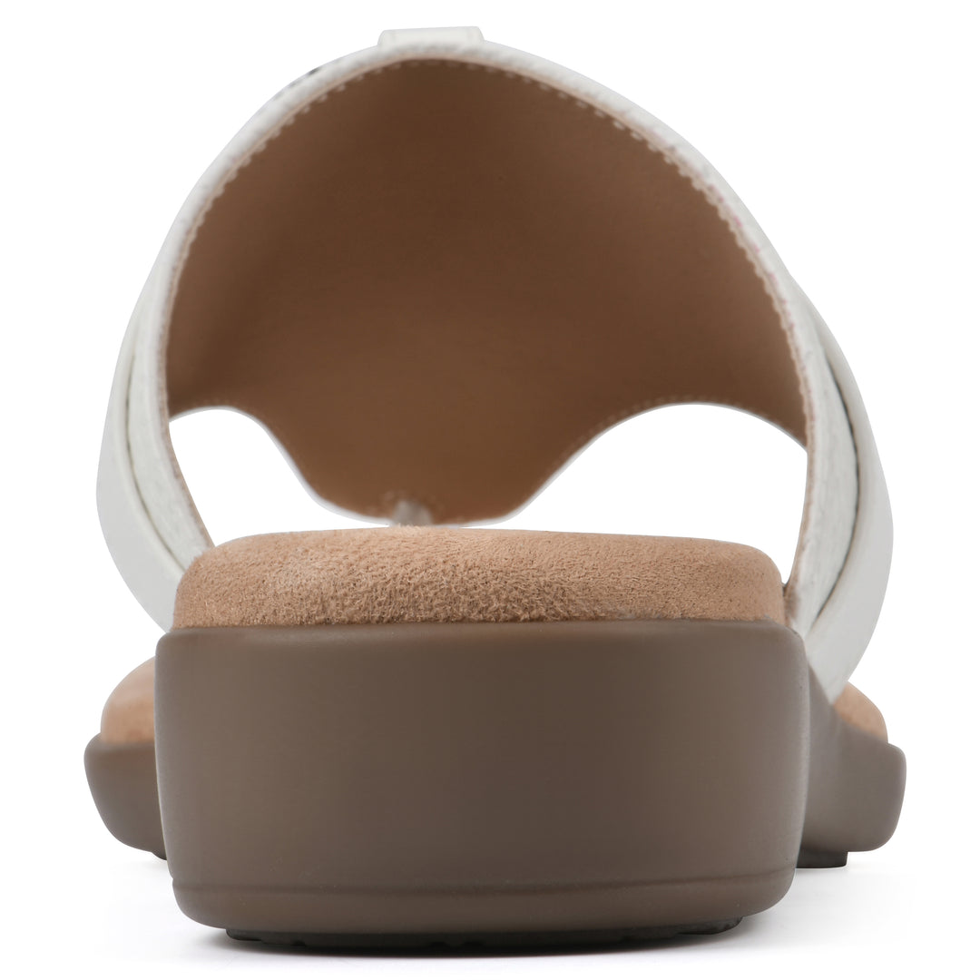 Rear view of a light beige thong sandal with a centered metal ring ornament and tan sole