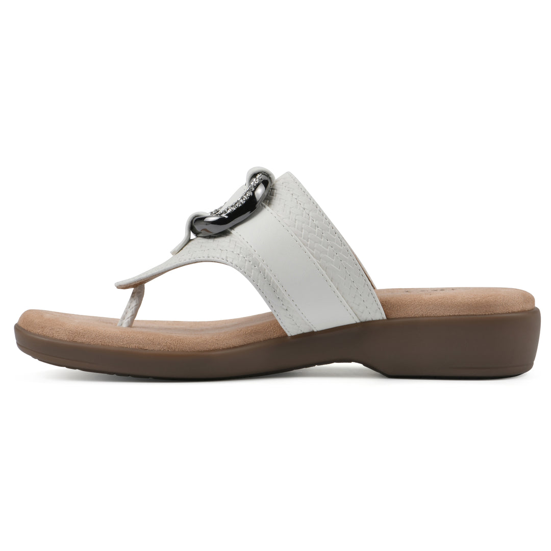 Side view of a light beige thong sandal with a centered metal ring ornament and tan sole