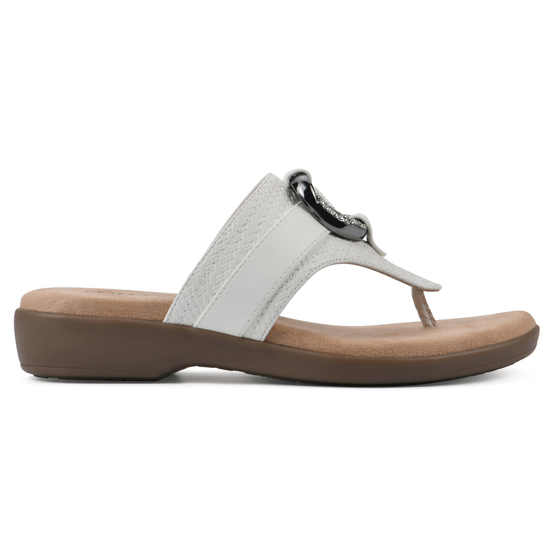 Side view of a white thong sandal with a centered metal ring ornament and tan sole