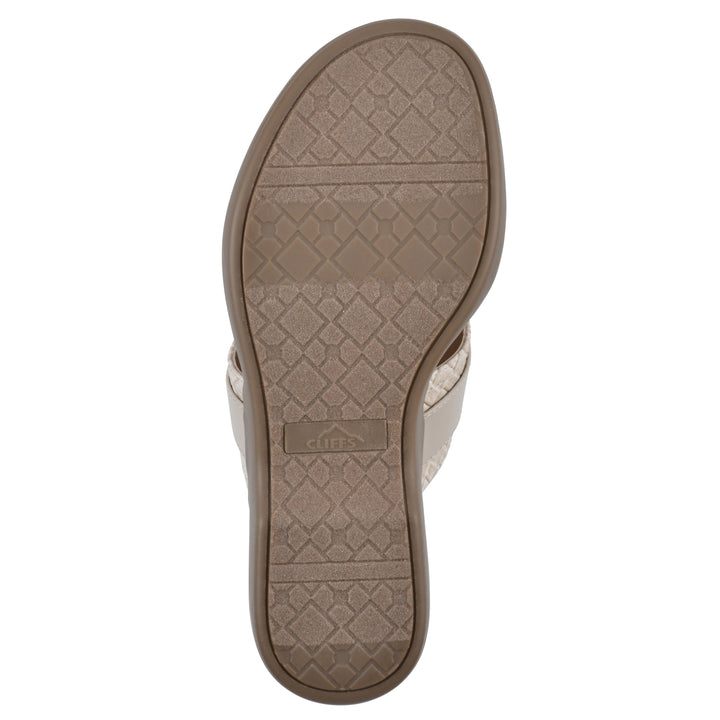 Sole view of a light beige thong sandal with a centered metal ring ornament and tan sole