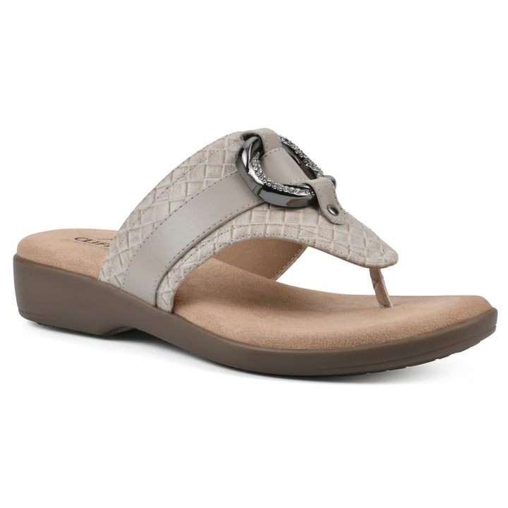 Angle view of a light beige thong sandal with a centered metal ring ornament and tan sole