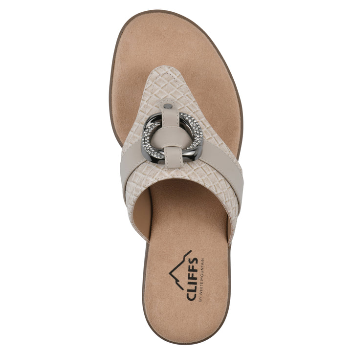 Top view of a light beige thong sandal with a centered metal ring ornament and tan sole