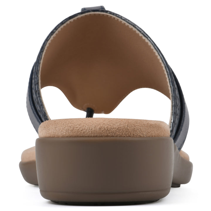 Rear view with a centered metal ring ornament and tan sole