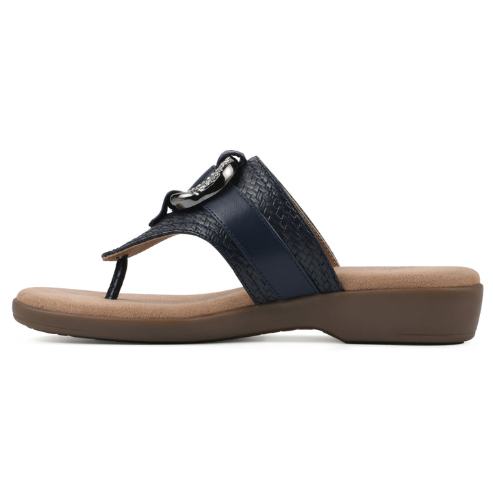 Side view of a navy thong sandal with a centered metal ring ornament and tan sole