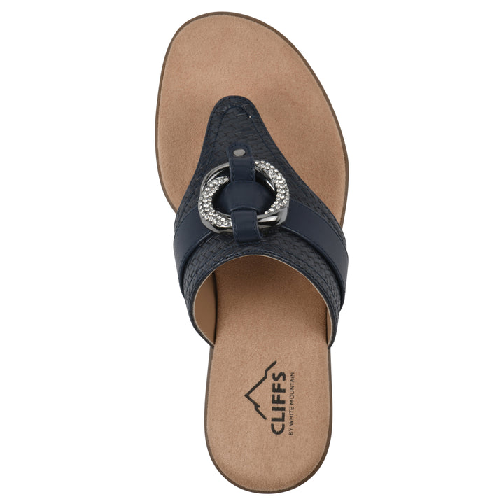 Top view of a navy thong sandal with a centered metal ring ornament and tan sole