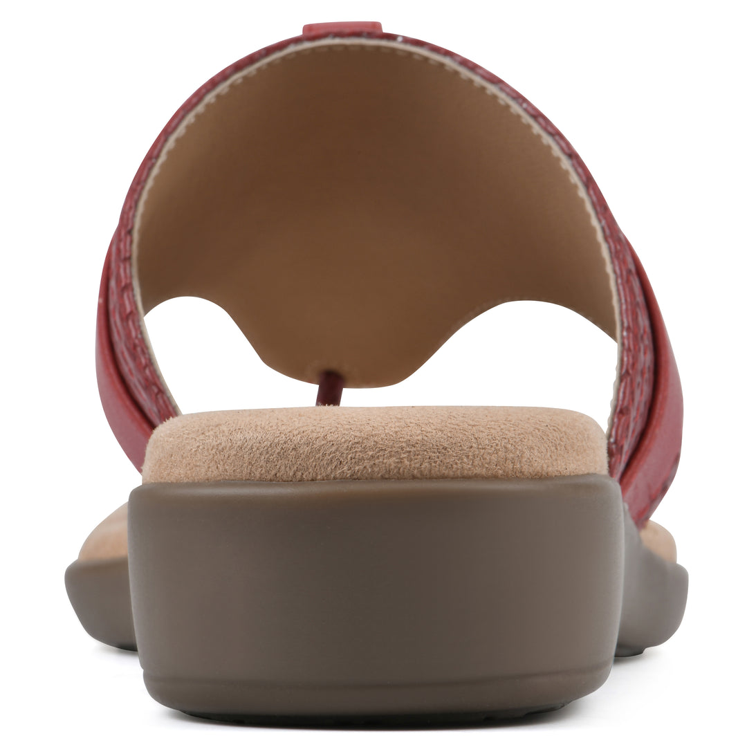 Rear view of a brick red thong sandal with a centered metal ring ornament and tan sole