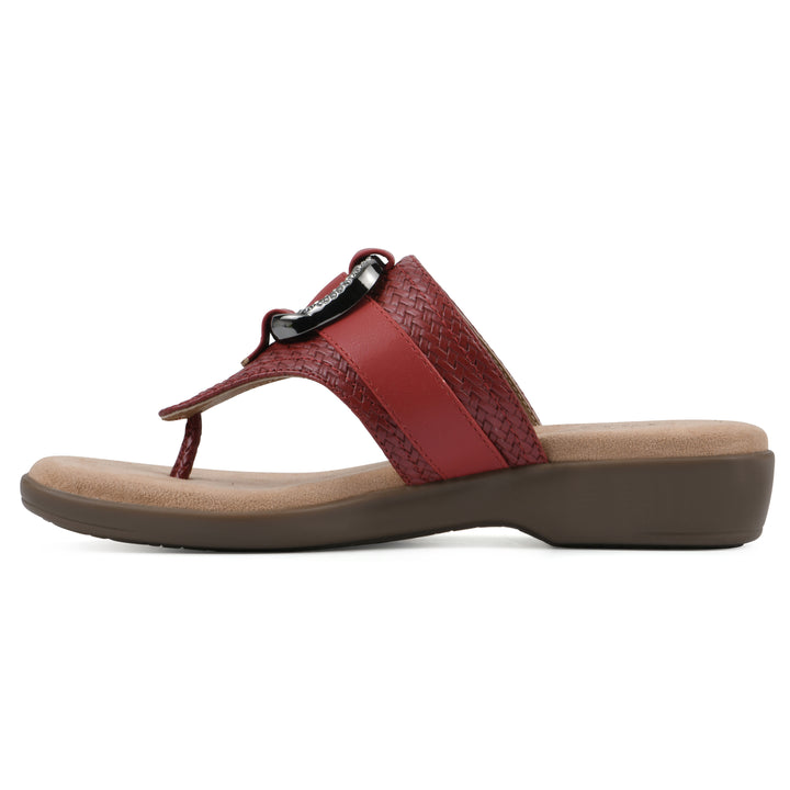 Side view of a brick red thong sandal with a centered metal ring ornament and tan sole