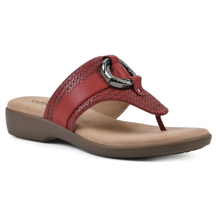 Angle view of a brick red thong sandal with a centered metal ring ornament and tan sole