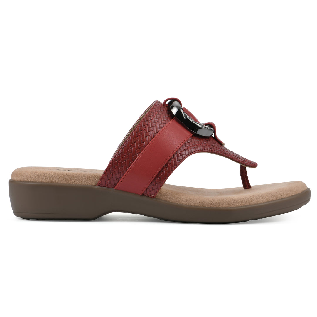 Side view of a brick red thong sandal with a centered metal ring ornament and tan sole