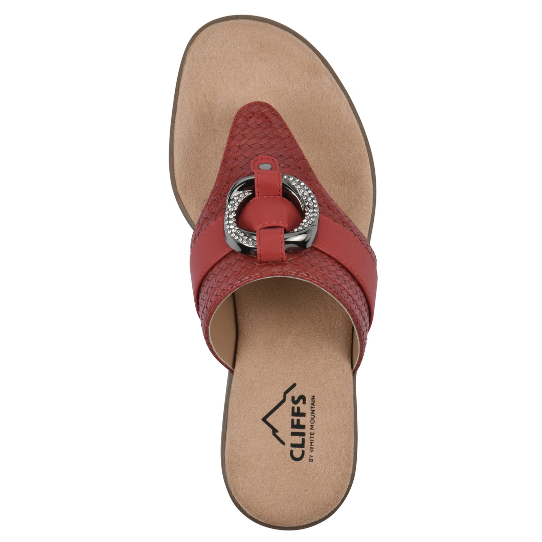 Top view of a brick red thong sandal with a centered metal ring ornament and tan sole
