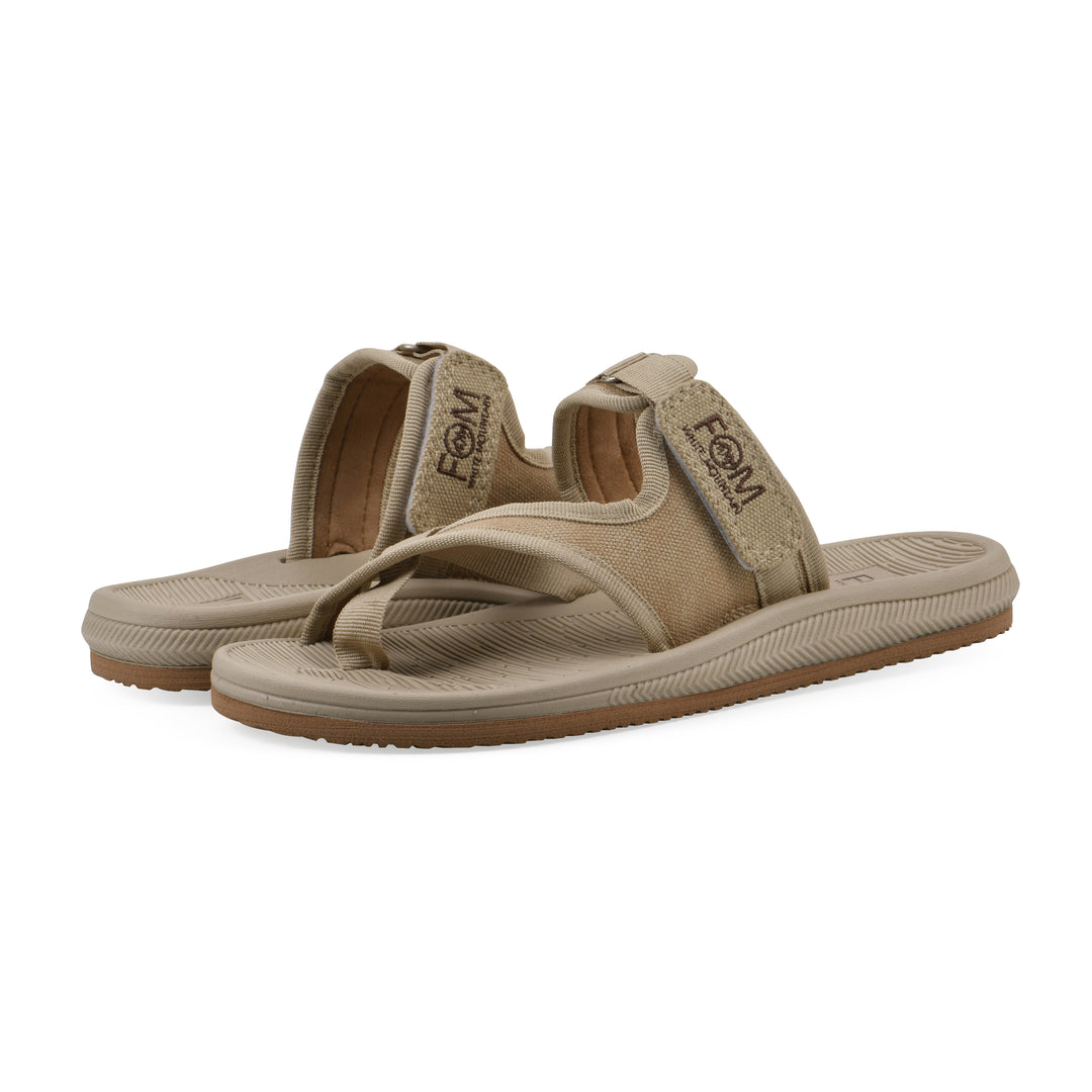 Angle view of a pair of khaki fabric thong sandal with velcro center strap and a tan sole
