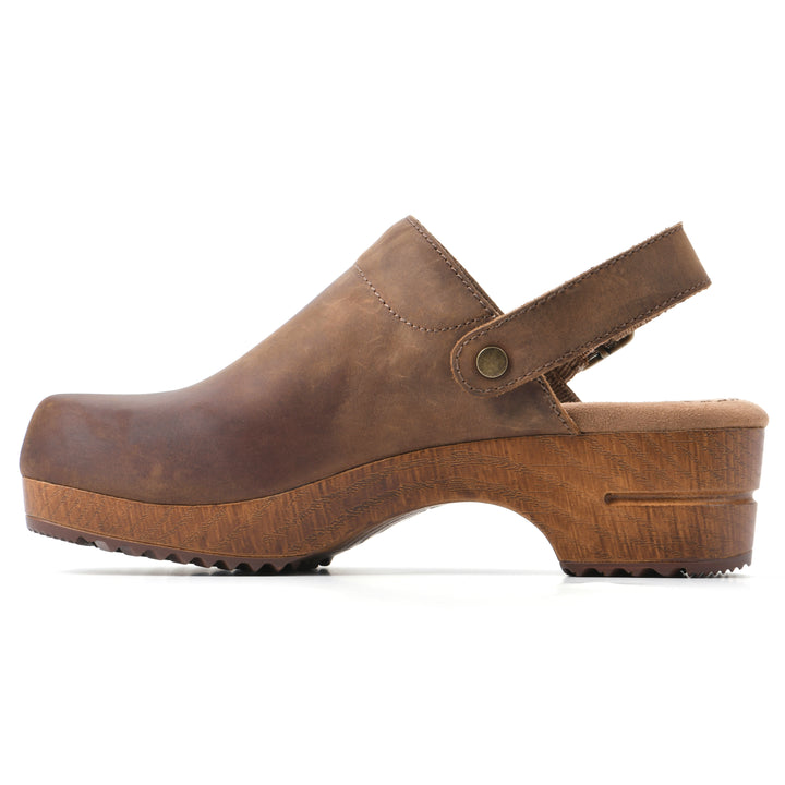 Side view of a backless brown leather clog with adjustable back strap and wood style heel