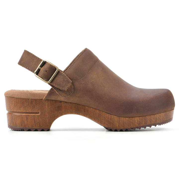 Side view of a backless brown leather clog with adjustable back strap and wood style heel