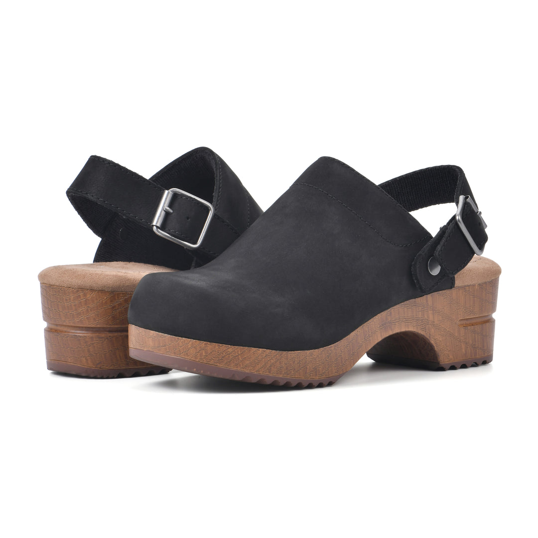 Angle view of a pair of backless black leather clogs with adjustable back strap and wood style heel