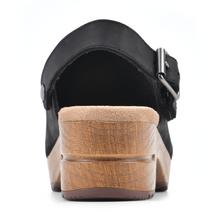 Rear view of a backless black leather clog with adjustable back strap and wood style heel