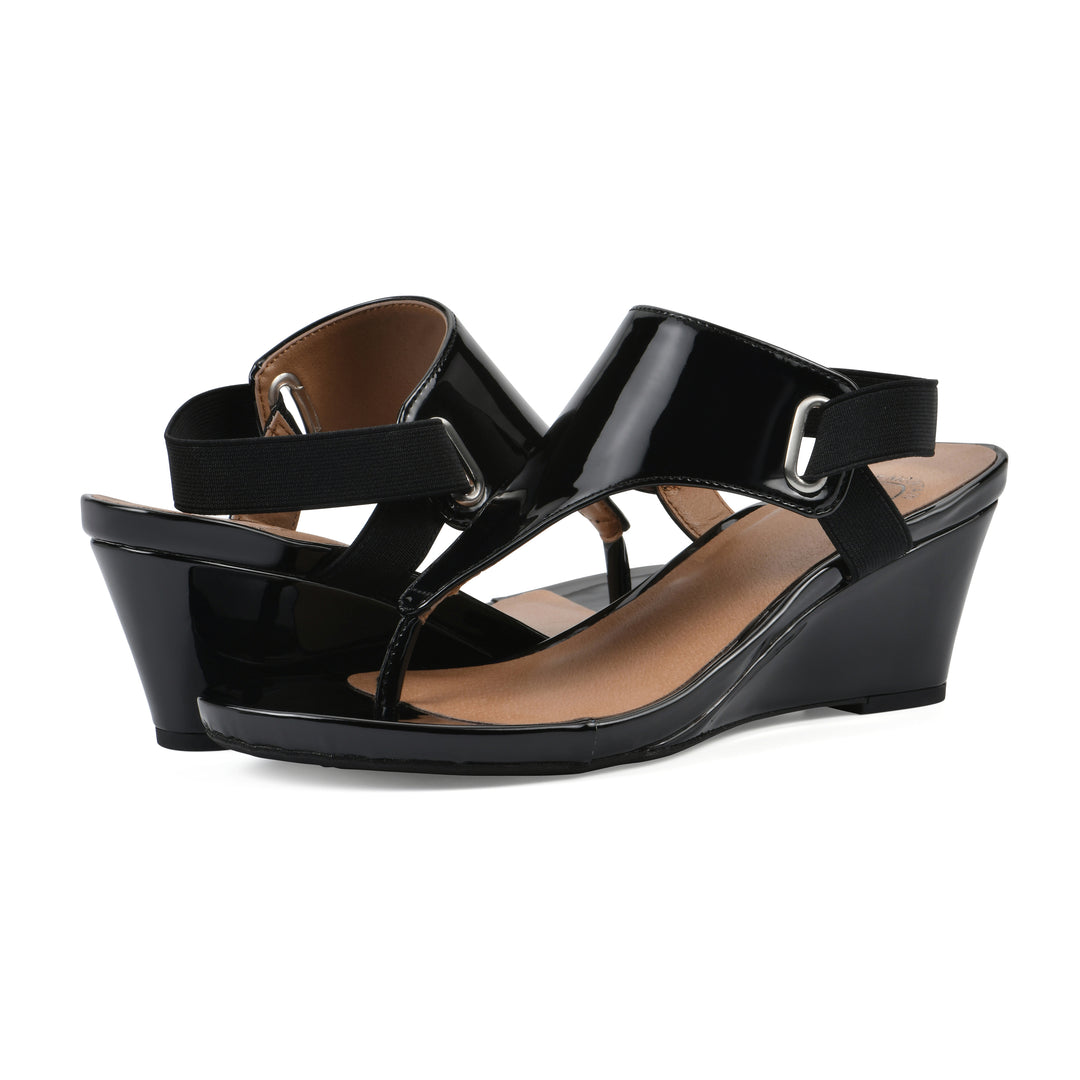 Angle view of a pair of black patent thong wedge sandals with a wrapped heel, elastic ankle strap, and black sole