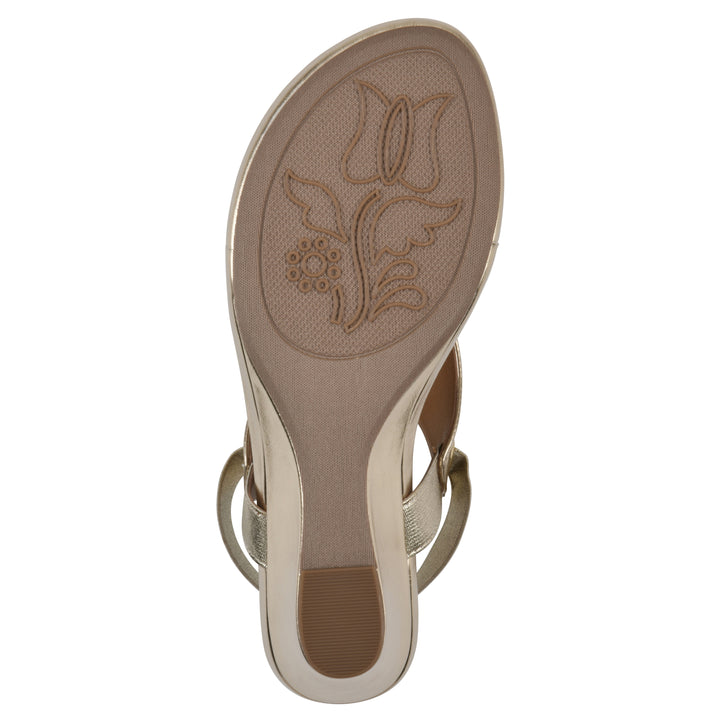 Sole view of a gold metallic thong wedge sandal with a wrapped heel, elastic ankle strap, and gold sole