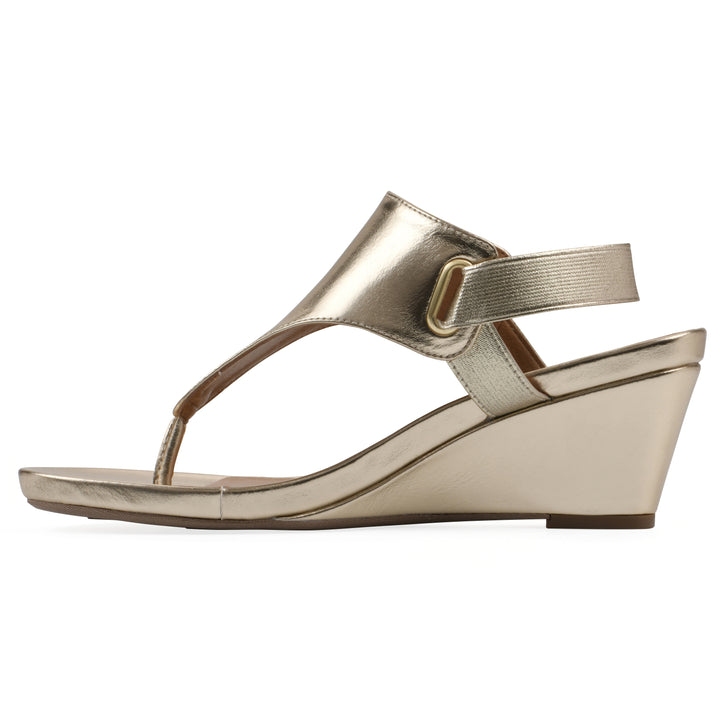 Side view of a gold metallic thong wedge sandal with a wrapped heel, elastic ankle strap, and gold sole