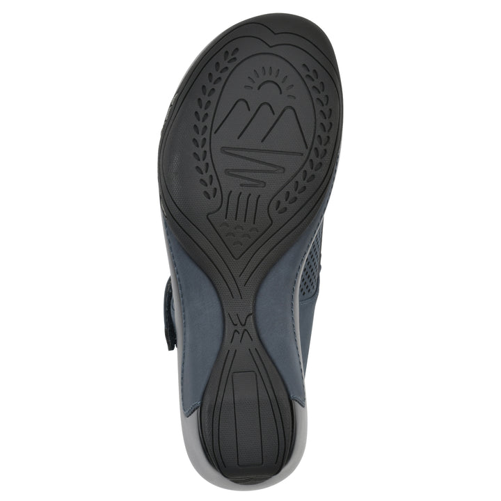 Sole view of a navy-colored clog with a closed toe and adjustable strap, featuring a perforated diamond design and a low heel.