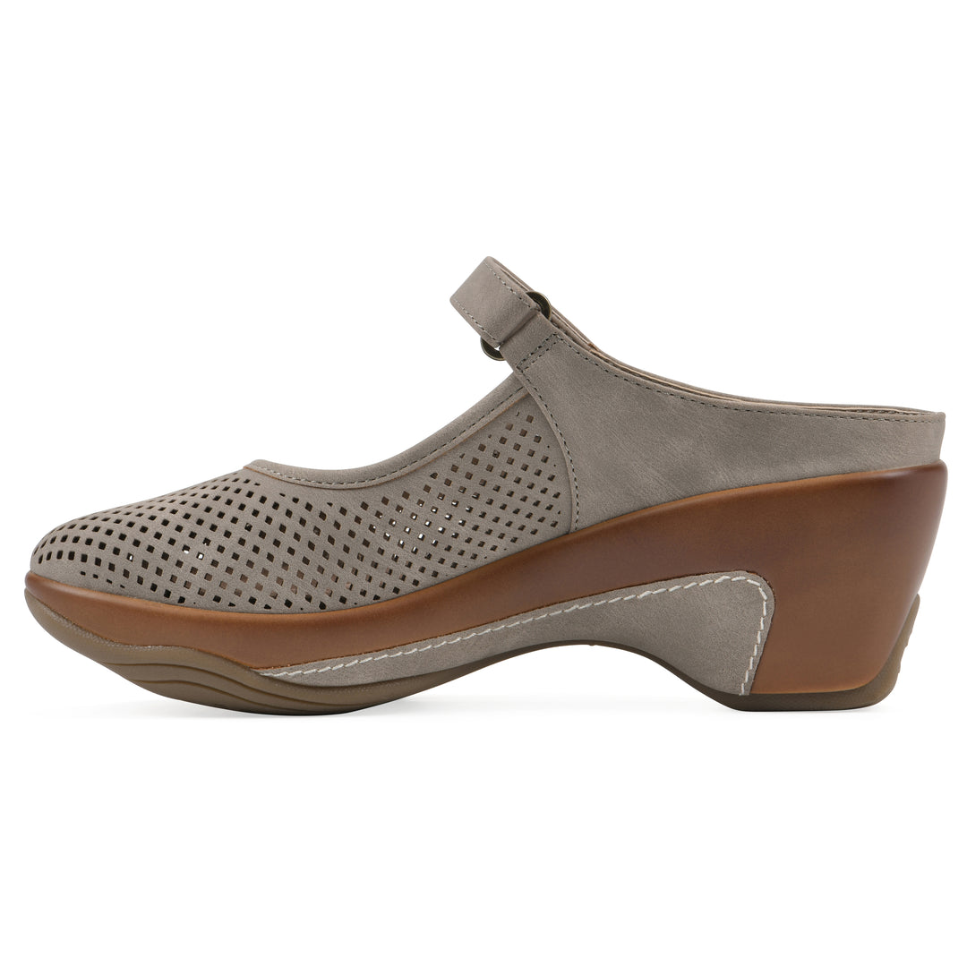 Side view of a light taupe-colored clog with a closed toe and adjustable strap, featuring a perforated diamond design and a low heel.
