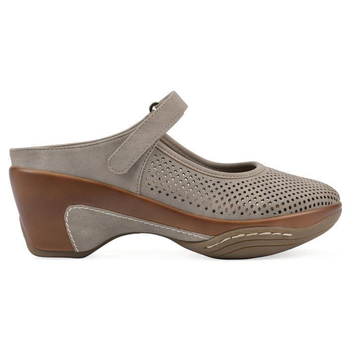 Side view of a light taupe-colored clog with a closed toe and adjustable strap, featuring a perforated diamond design and a low heel.