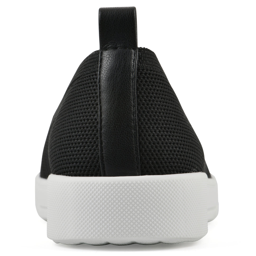 Heel view of a black slip-on sneaker with white sole, and perforated mesh fabric