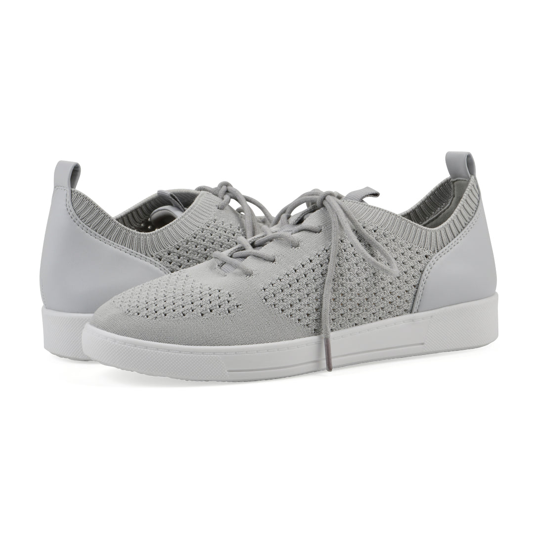Angle view of a pair of gray sneakers with white sole, lace-up design and perforated mesh fabric