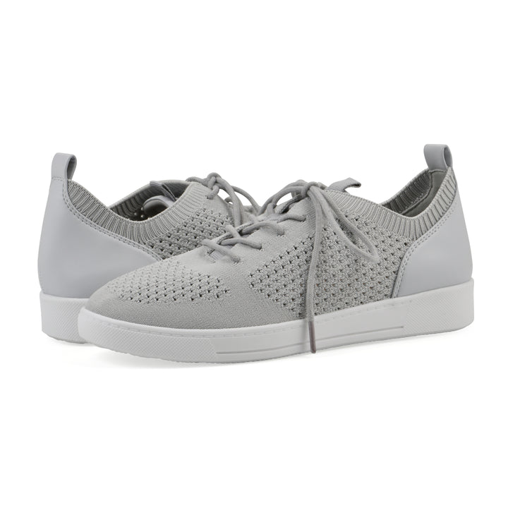 Angle view of a pair of gray sneakers with white sole, lace-up design and perforated mesh fabric