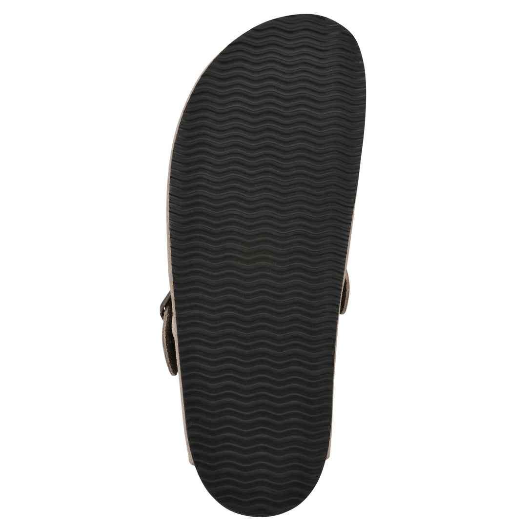 Sole view of a tan suede backless clog with an adjustable buckle strap with stud and eyelet detailing and a black sole