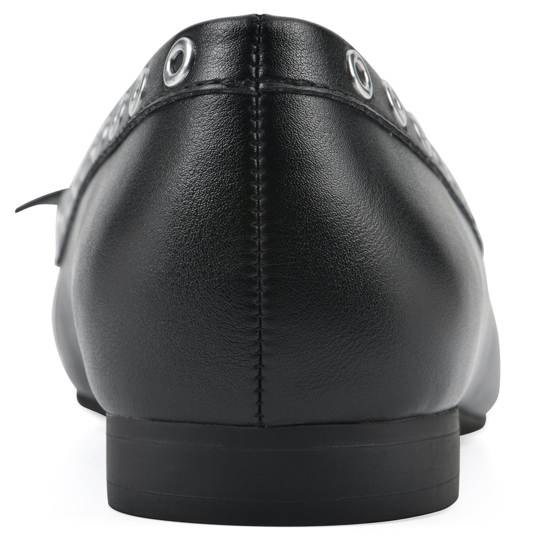 Rear view of a black faux leather flat with small, centered bow, silver metal grommet lining and a black sole
