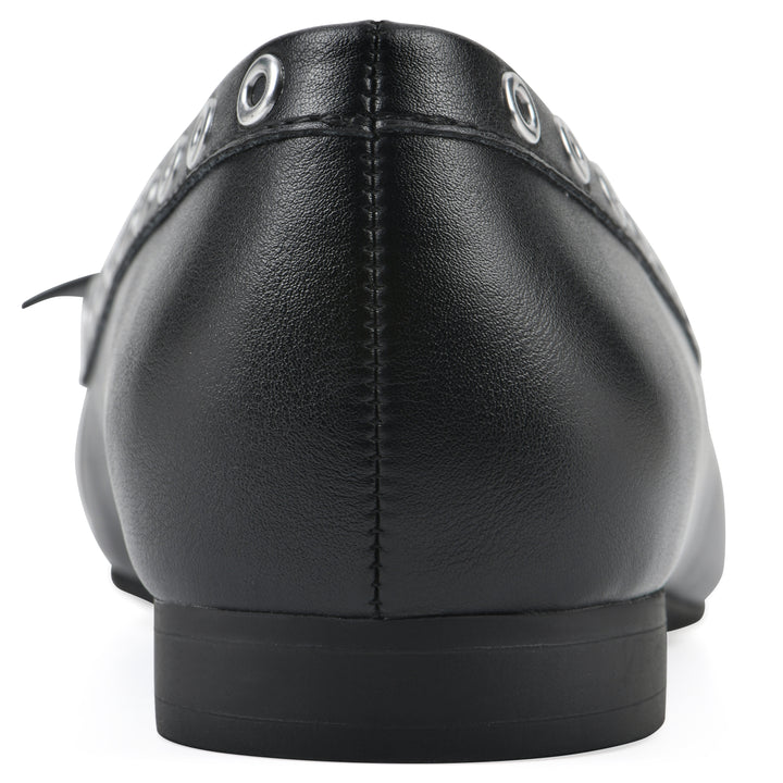 Rear view of a black faux leather flat with small, centered bow, silver metal grommet lining and a black sole