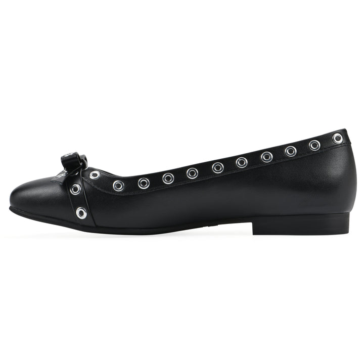 Side view of a black faux leather flat with small, centered bow, silver metal grommet lining and a black sole