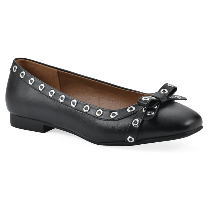 Angle view of a black faux leather flat with small, centered bow, silver metal grommet lining and a black sole