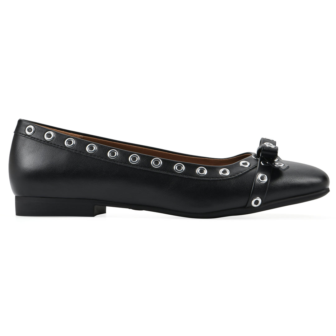 Side view of a black faux leather flat with small, centered bow, silver metal grommet lining and a black sole