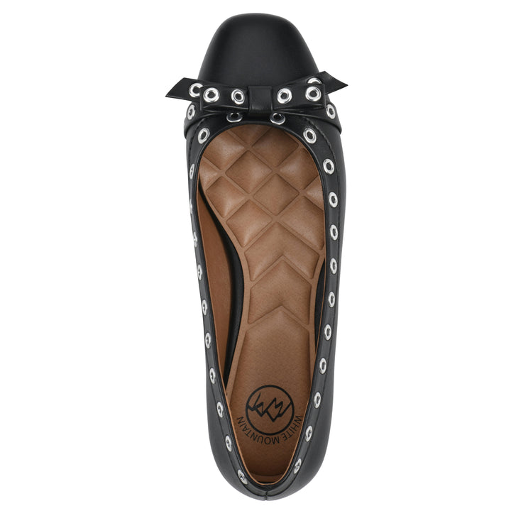 Top view of a black faux leather flat with small, centered bow, silver metal grommet lining and a black sole