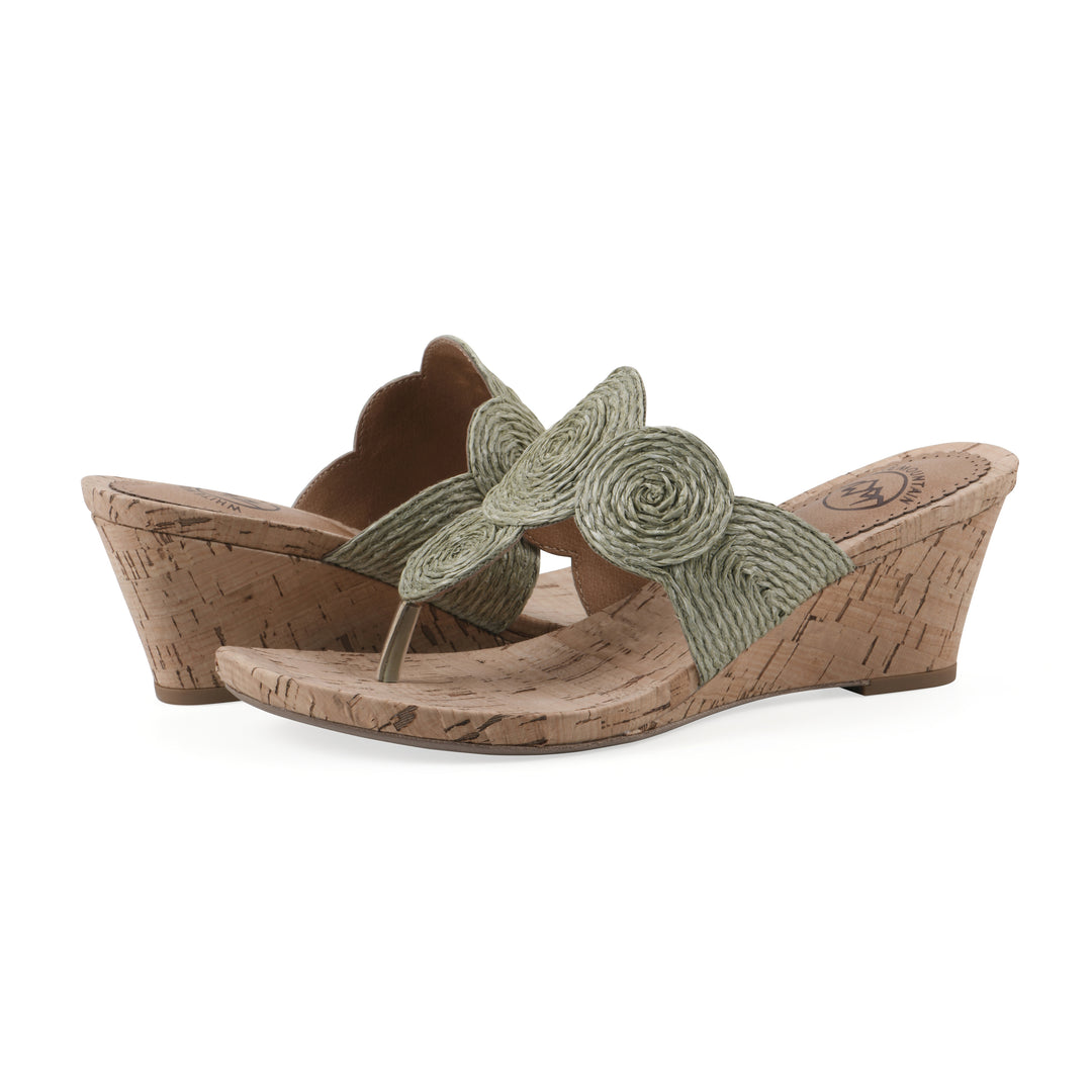 Angle view of a pair of cork print wedge sandal with green raffia thong design 
