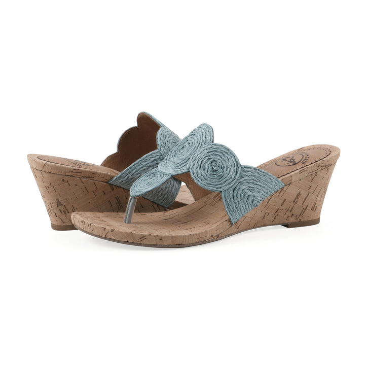 Angle view of a pair of cork print wedge sandal with light blue raffia thong design 