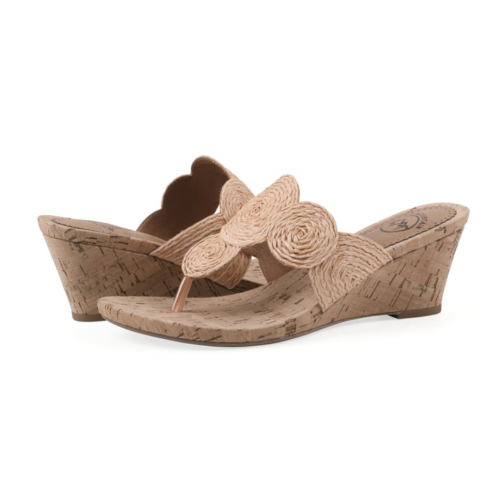 Angle view of a pair of cork print wedge sandal with natural apricot color raffia thong design 