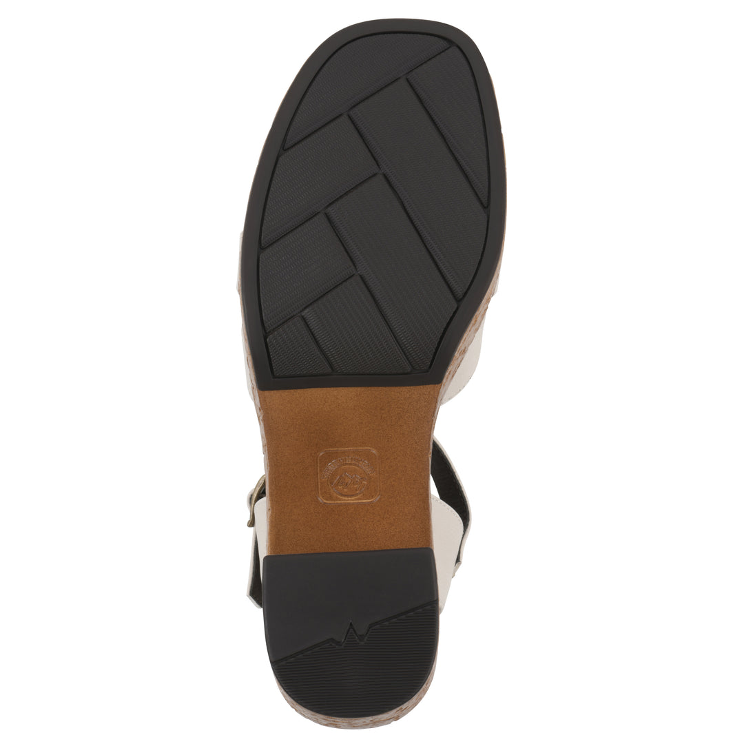 Sole view of a cream faux leather platform sandal with buckle style ankle strap and a brown molded cork bottom