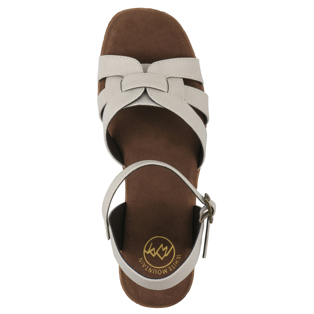 Top view of a cream faux leather platform sandal with buckle style ankle strap and a brown molded cork sole