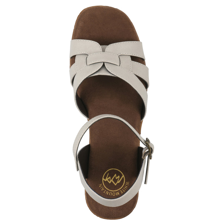 Top view of a cream faux leather platform sandal with buckle style ankle strap and a brown molded cork sole
