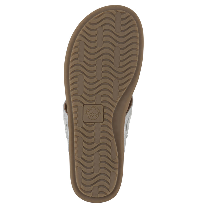 Sole view of a silver thong sandal with metal embellishment and a brown sole