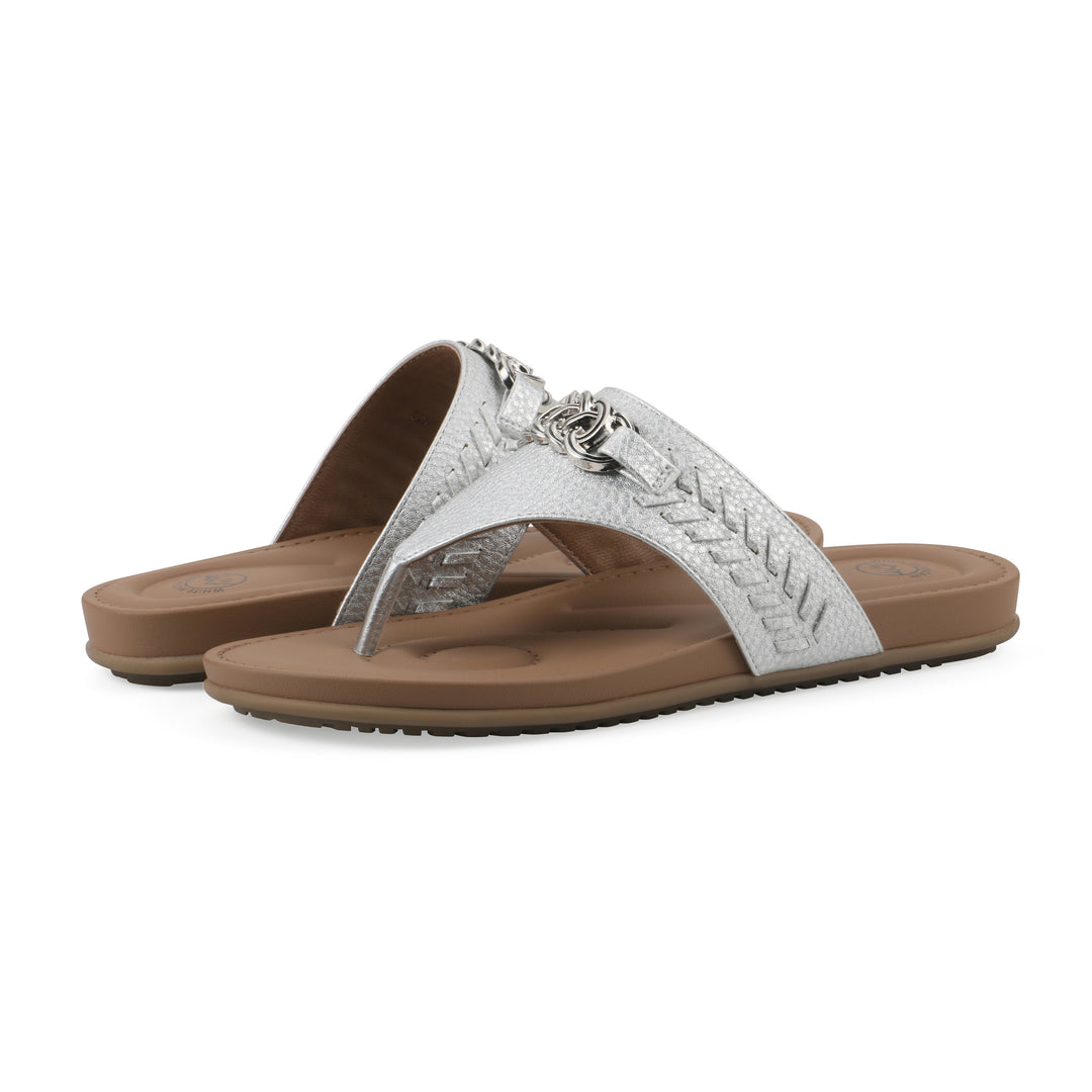 Angle view of a pair of silver thong sandals with metal embellishment and a brown sole