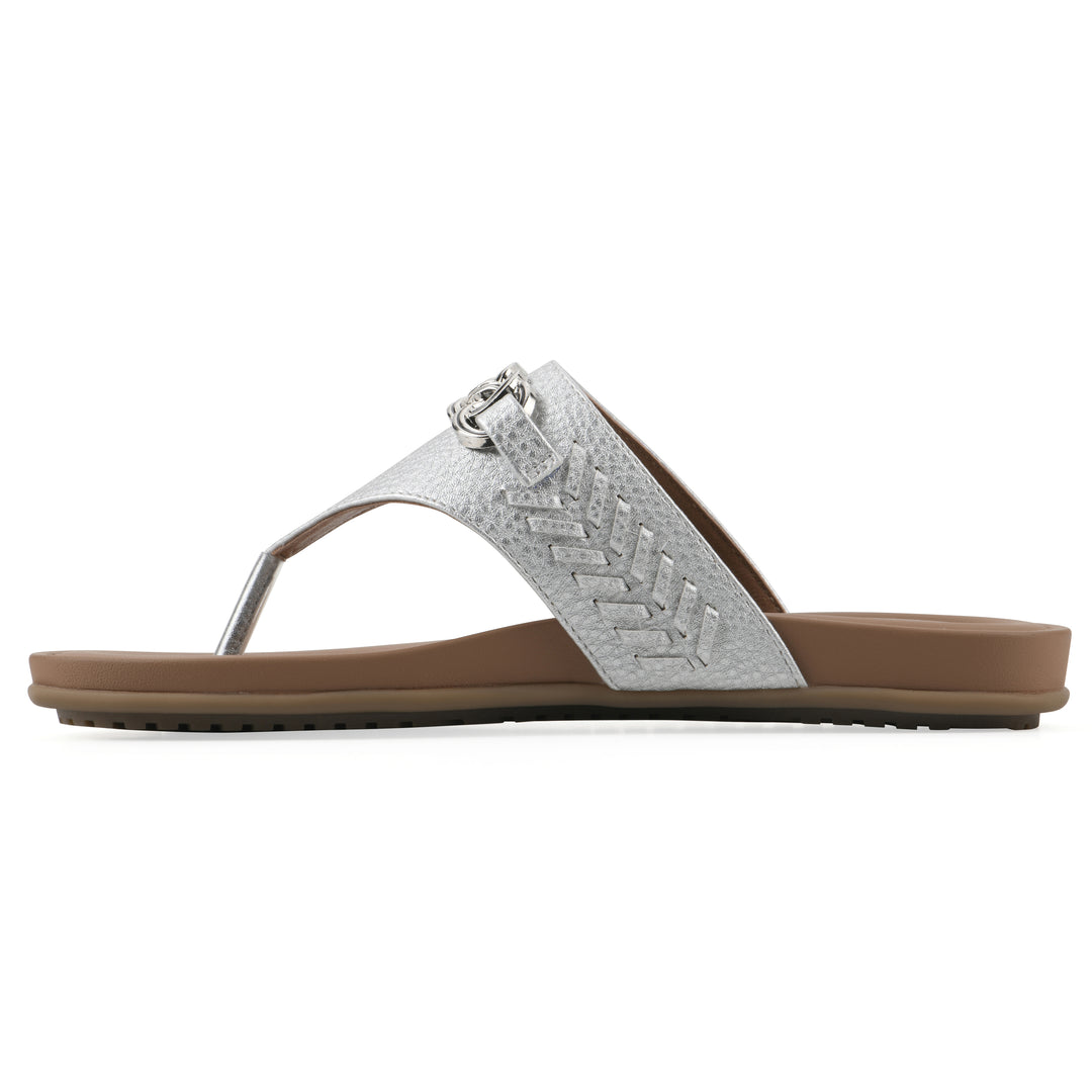 Side view of a silver thong sandal with metal embellishment and a brown sole