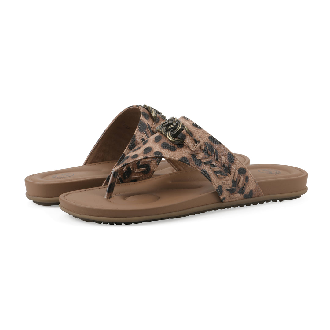 Angle view of a pair of leopard print thong sandals with metal embellishment and a brown sole