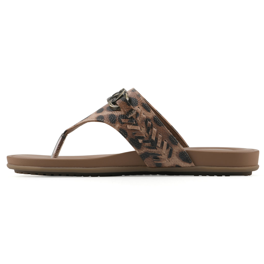 Side view of a leopard print thong sandal with metal embellishment and a brown sole