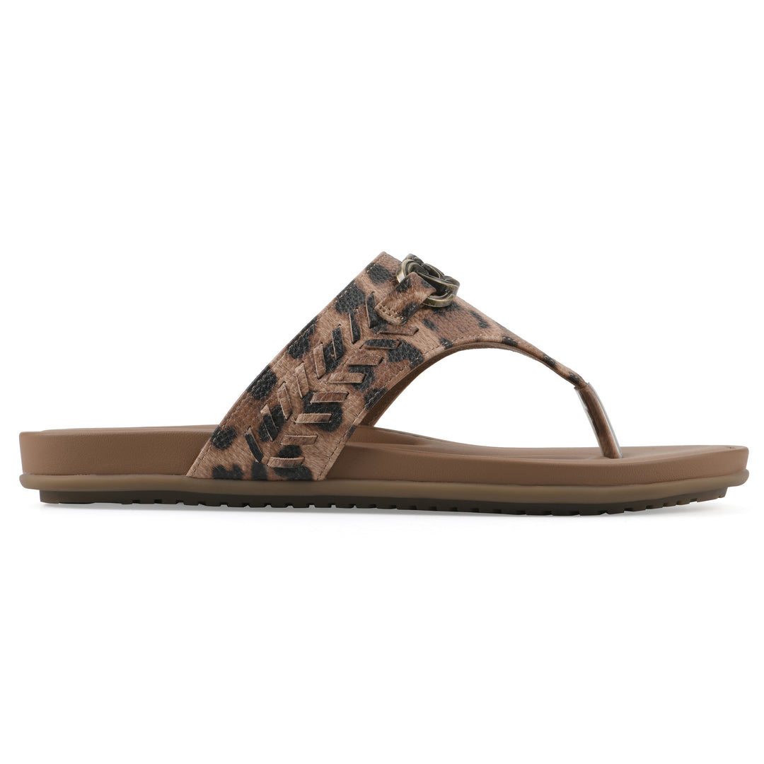Side view of a leopard print thong sandal with metal embellishment and a brown sole