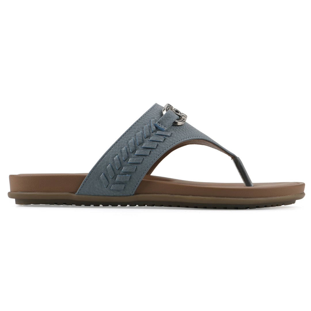Side view of a blue thong sandal with metal embellishment and a brown sole