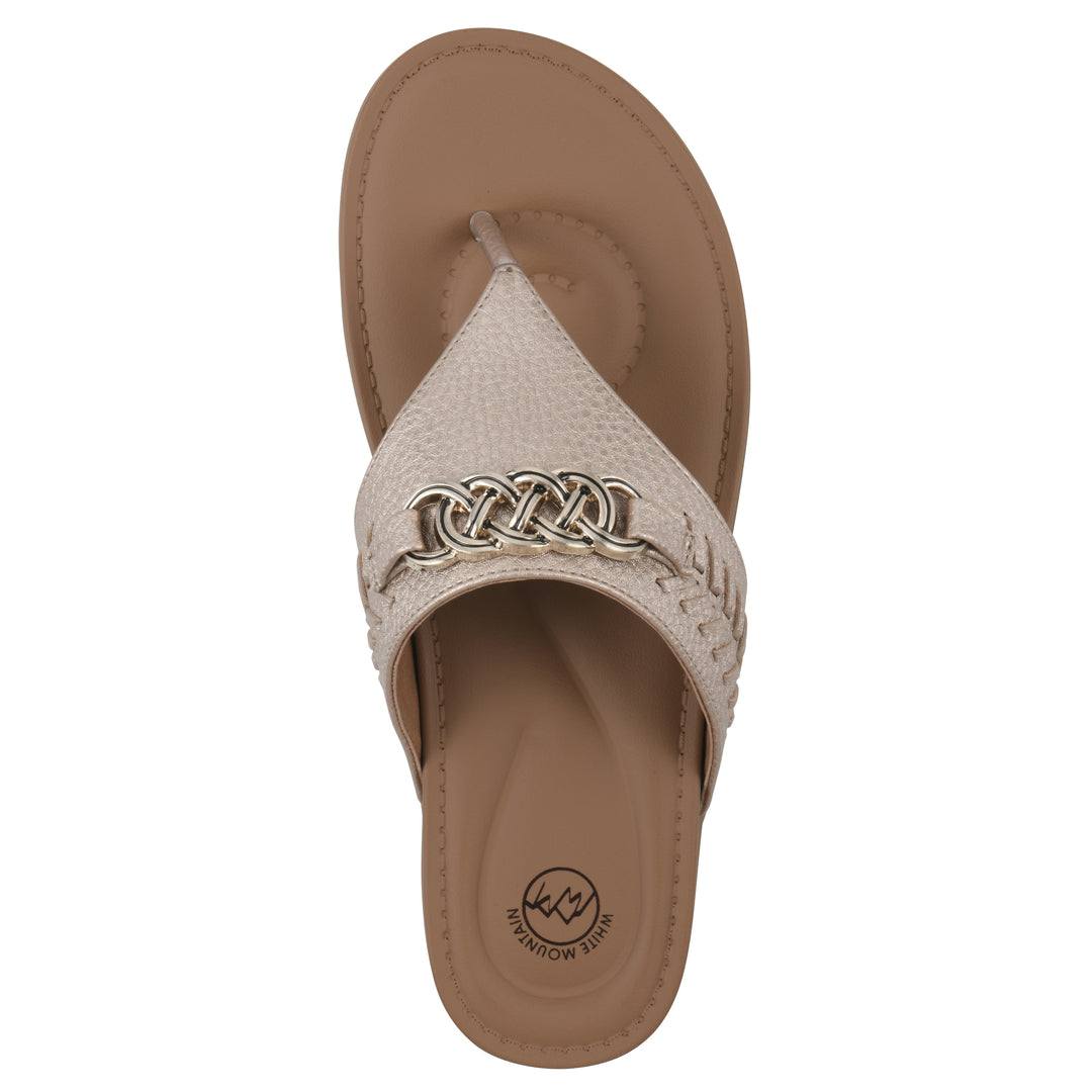 Top view of a light gold thong sandal with metal embellishment and a brown sole